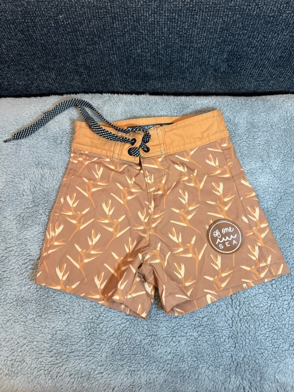 Kid’s board shorts in Torch Ginger Red Dirt